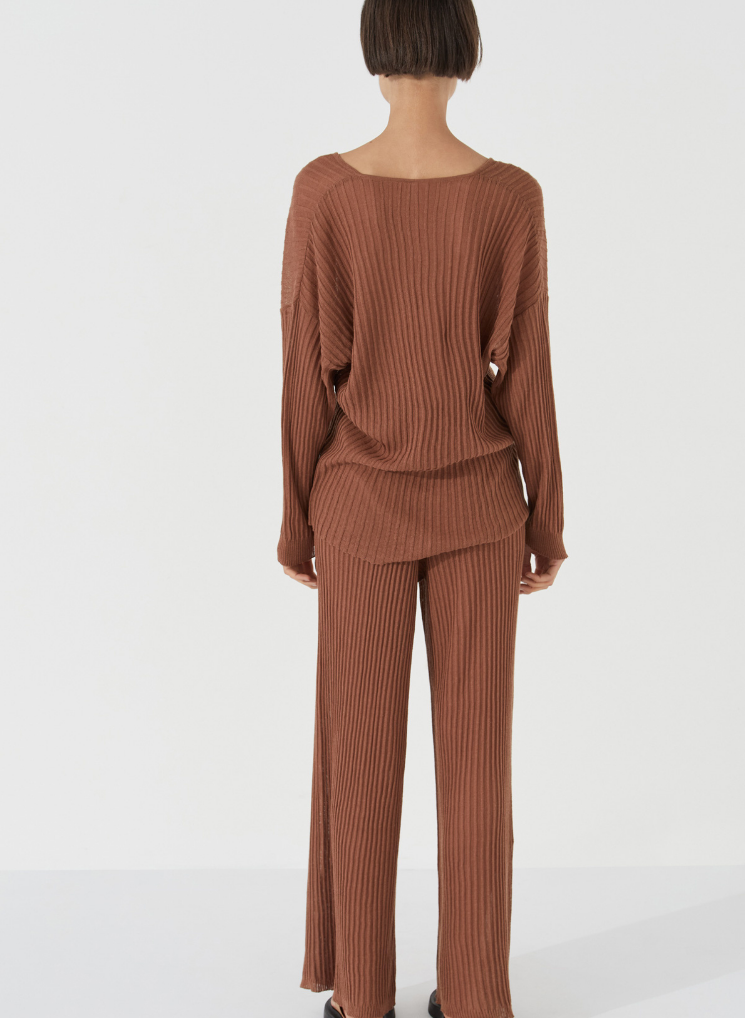 The Ribbed Knit Top by Zulu & Zephyr is a textured sheer fine knit, featuring a casual long sleeve with drop shoulder, and feminine V neckline. Inspired by the drape of tactile cloth and soft organic forms, this transeasonal essential may be paired with the coordinating Ribbed Knit Pants.